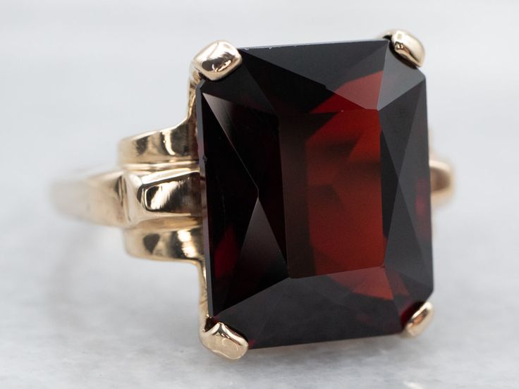 The garnet in this show-stopping statement ring is a deep crimson hue with electric flashes of cherry red sparkling from within. The emerald cut of the gemstone is a nice twist on traditional cocktail rings. With its high profile and sleek design, this ring commands attention!Metal: 10K Yellow GoldGem: Pyrope Garnet 10.40 CaratsGem Measurements: 10.6 x 13.3 mm, Emerald CutRing Size: 5Marks: "10K" Stamped on the inside band Mens Ruby Ring, Garnet Statement Ring, Gold Garnet Ring, Amethyst Cocktail Ring, Pyrope Garnet, Emerald Cut Ring, Emerald Cut Rings, Tanzanite Diamond, Gold Cocktail Ring