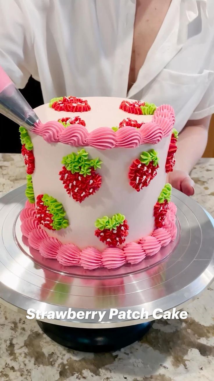 a woman is cutting into a strawberry cake