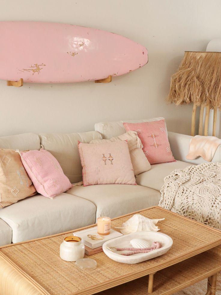 a living room with a couch, coffee table and surfboard on the wall above it