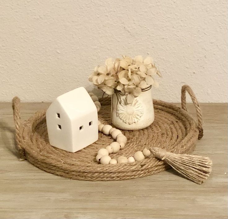 a vase with flowers and two white dices on a rope next to a flower pot