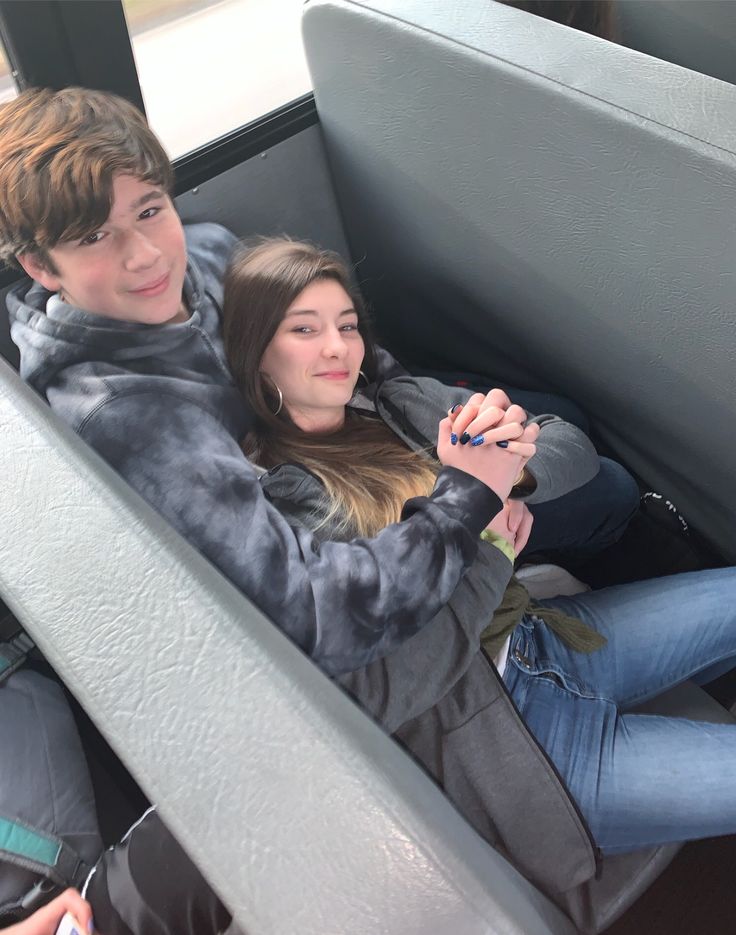 a man and woman sitting in the back of a bus