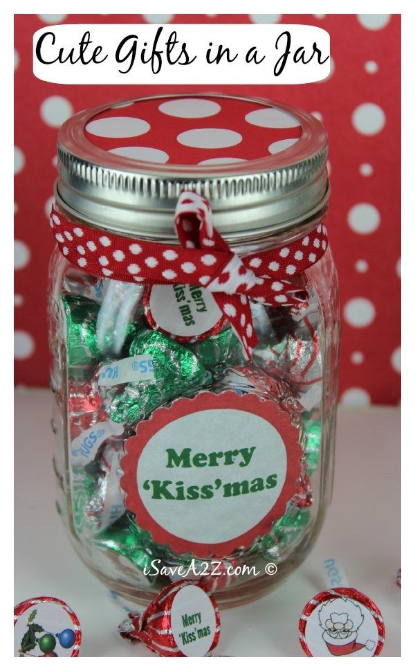 a jar filled with lots of candy sitting on top of a white table next to red and white polka dots