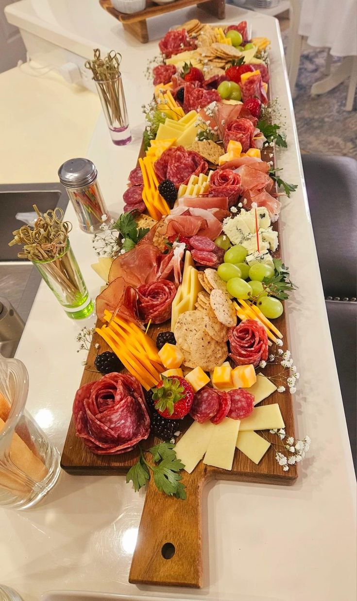 a long platter filled with lots of different types of cheeses and meats