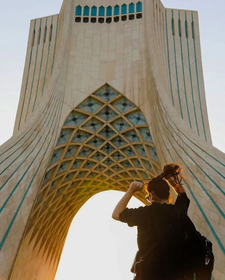 a woman standing in front of a tall building