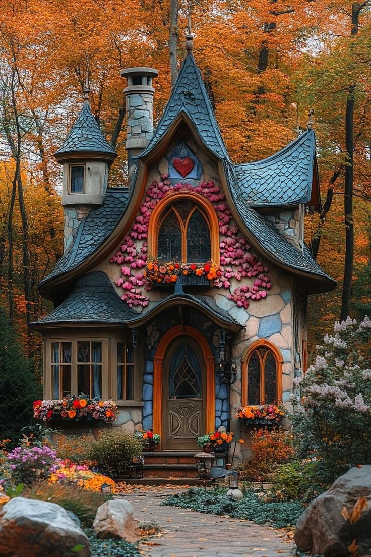 a small house with flowers on the roof and windows in front of it, surrounded by trees