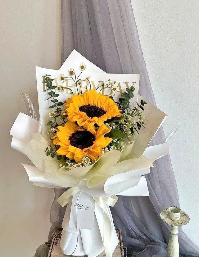 a bouquet of sunflowers in front of a window