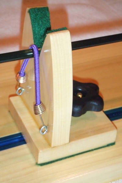 a piece of wood with a purple cord attached to it and an object in the background