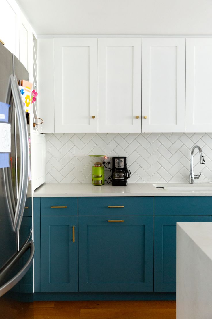 a kitchen with blue cabinets and white counter tops