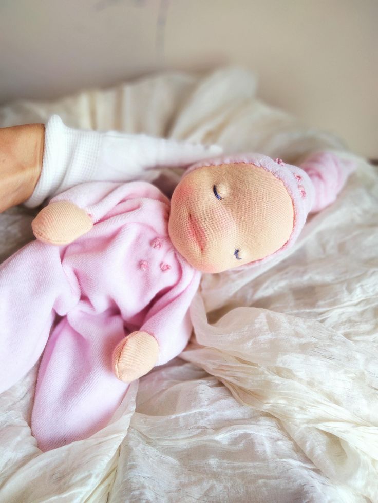 a baby doll laying on top of a bed