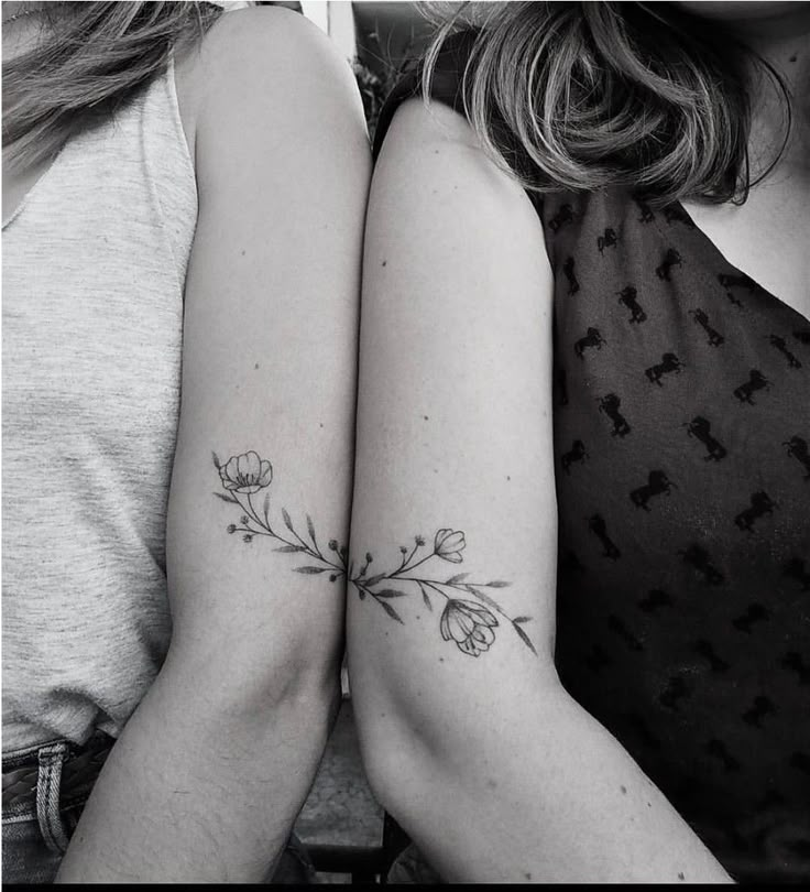 two women with matching tattoos on their arms