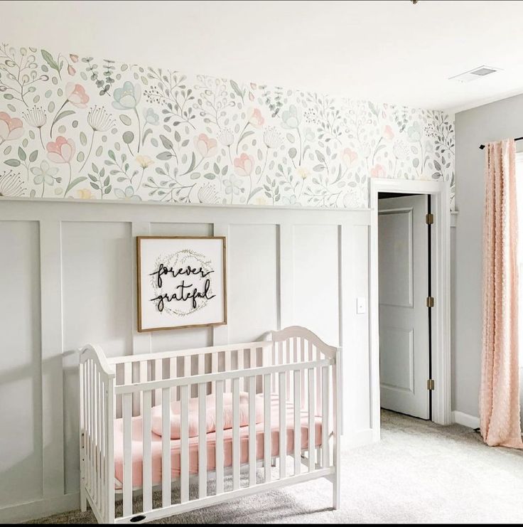 a baby's room with floral wallpaper and white crib in the corner