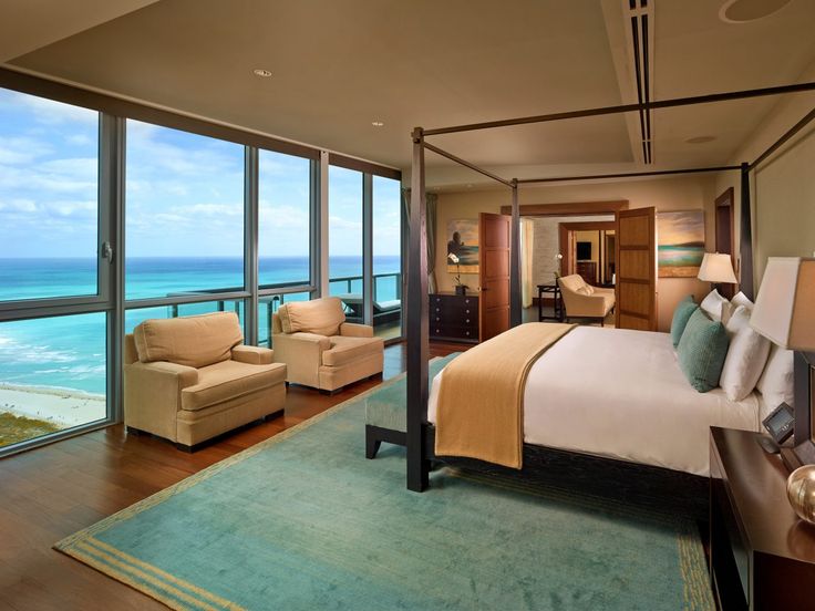 a bedroom with a large bed and ocean view