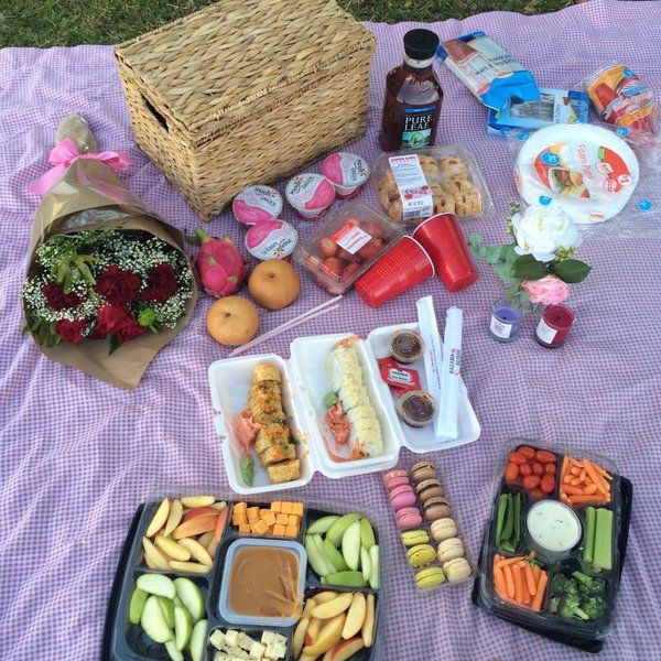 a picnic table with food and drinks on it, including salads, fruit, and vegetables