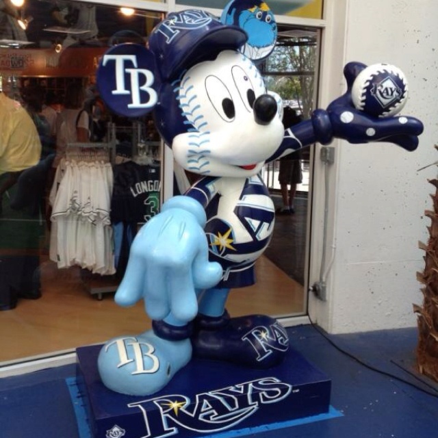 a mickey mouse statue in front of a store