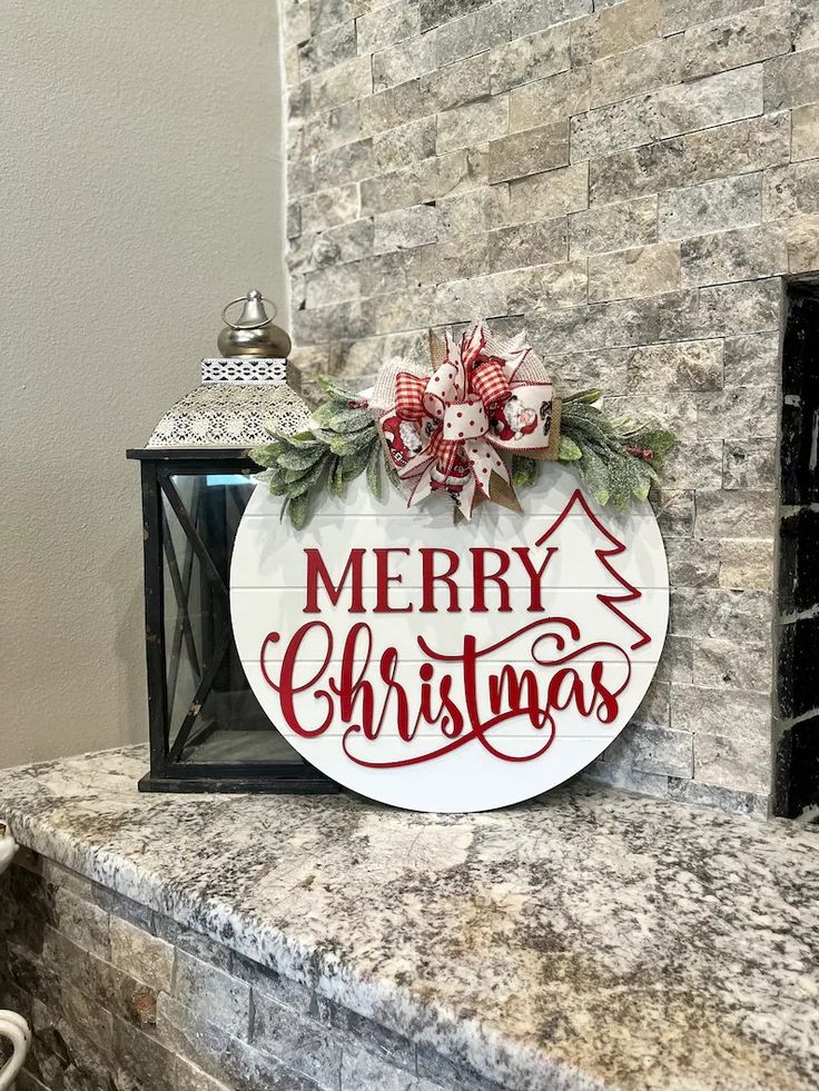 a merry christmas sign sitting on top of a fireplace mantle next to a brick wall