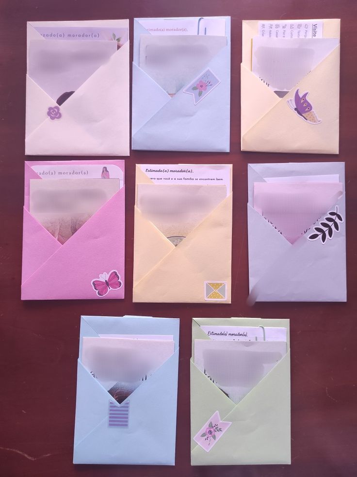 six envelopes with different designs on them sitting next to each other and one has a butterfly in it