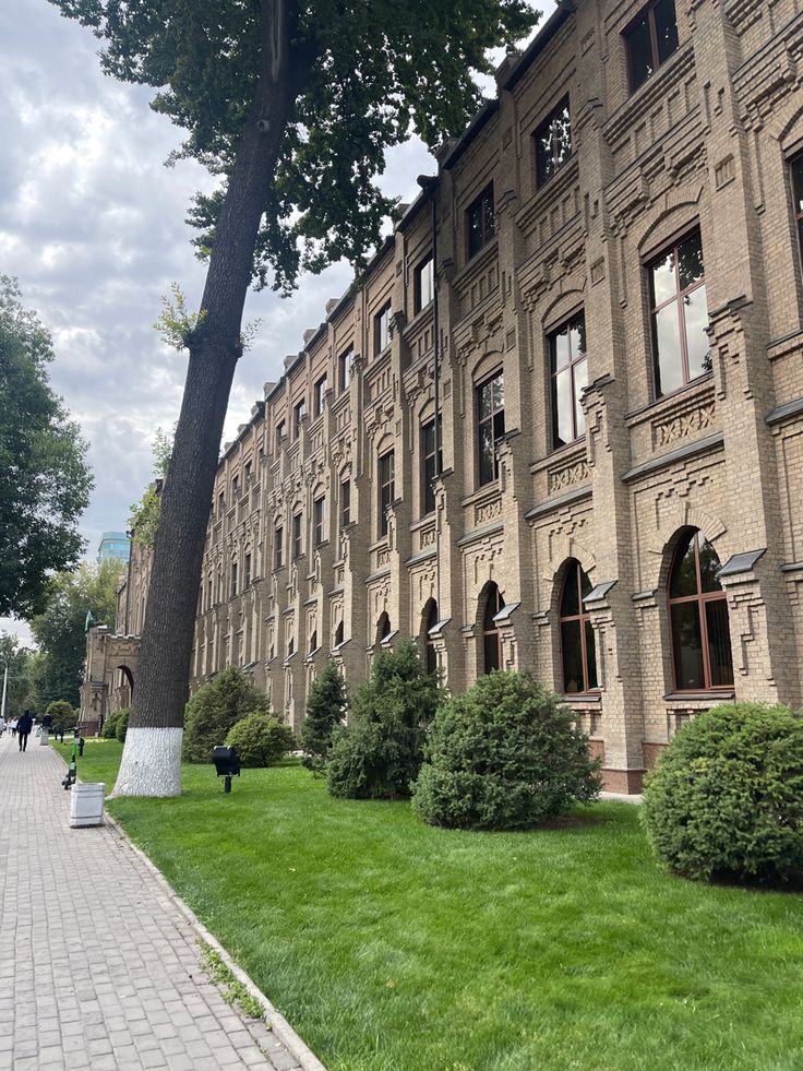 an old building with many windows and trees