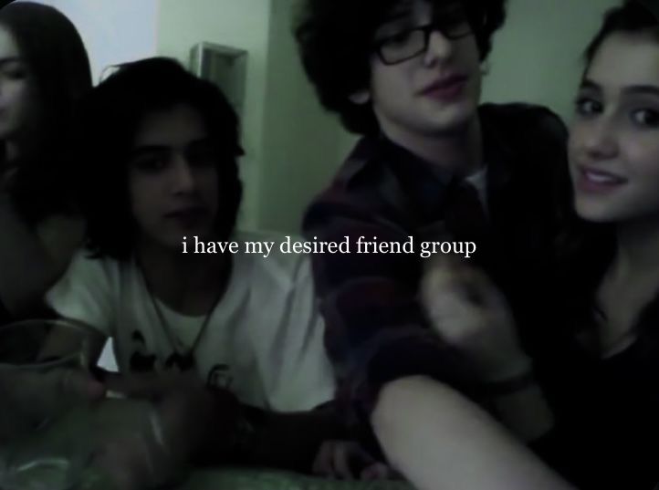 group of young people sitting together in a room with text on the wall above them