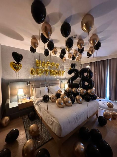 a bedroom decorated with black and gold balloons