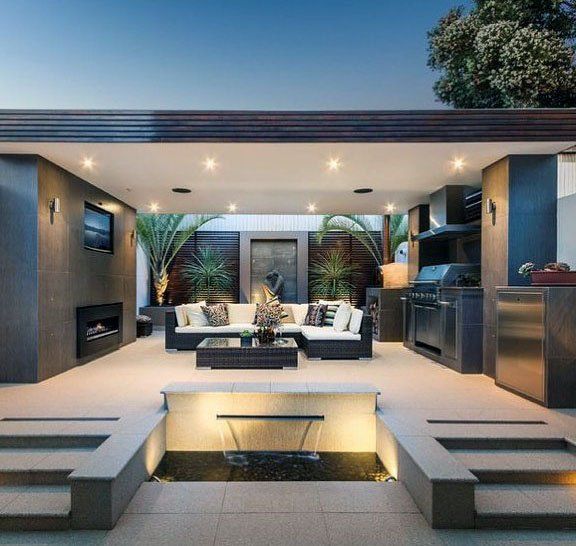 an outdoor living area with couches, tables and fire pit in the middle of it