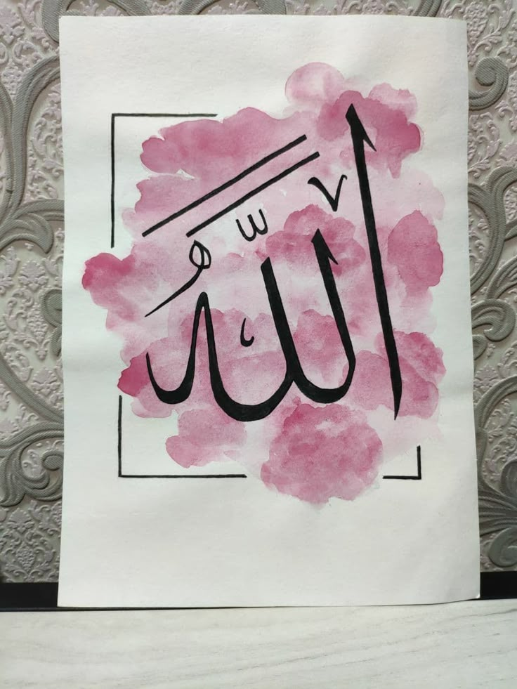 a piece of paper with an arabic writing on it and some pink watercolors