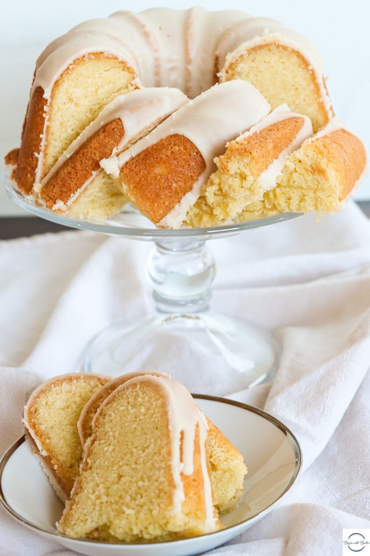 a bundt cake with white icing on a plate next to another bundt cake