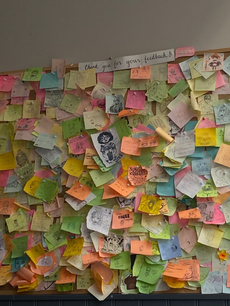 a bulletin board covered in lots of post it notes