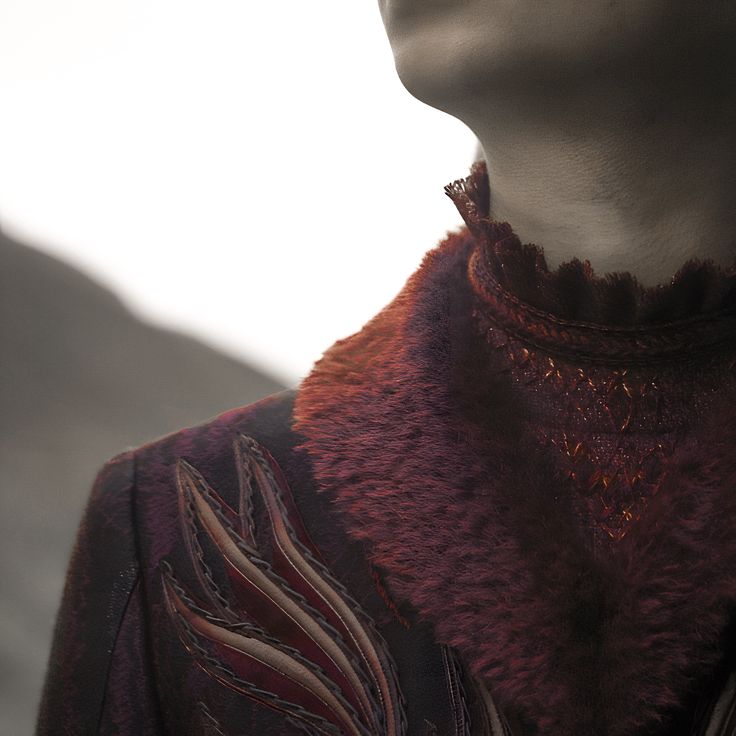 a mannequin's neck is adorned with an elaborate necklace and brooch