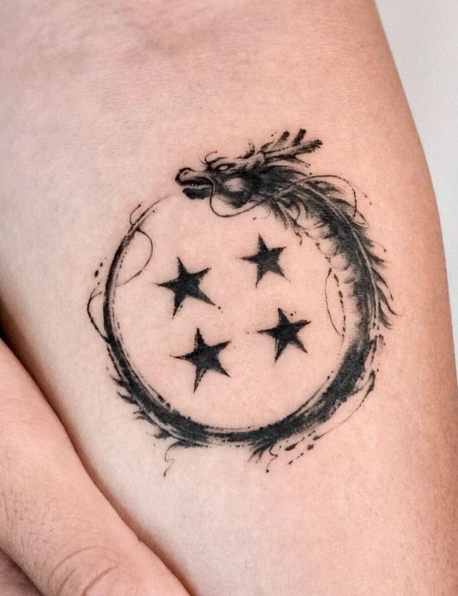 a woman's thigh with stars and a dragon tattoo on it, in black ink