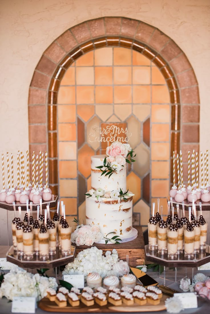 a table topped with lots of cakes and cupcakes