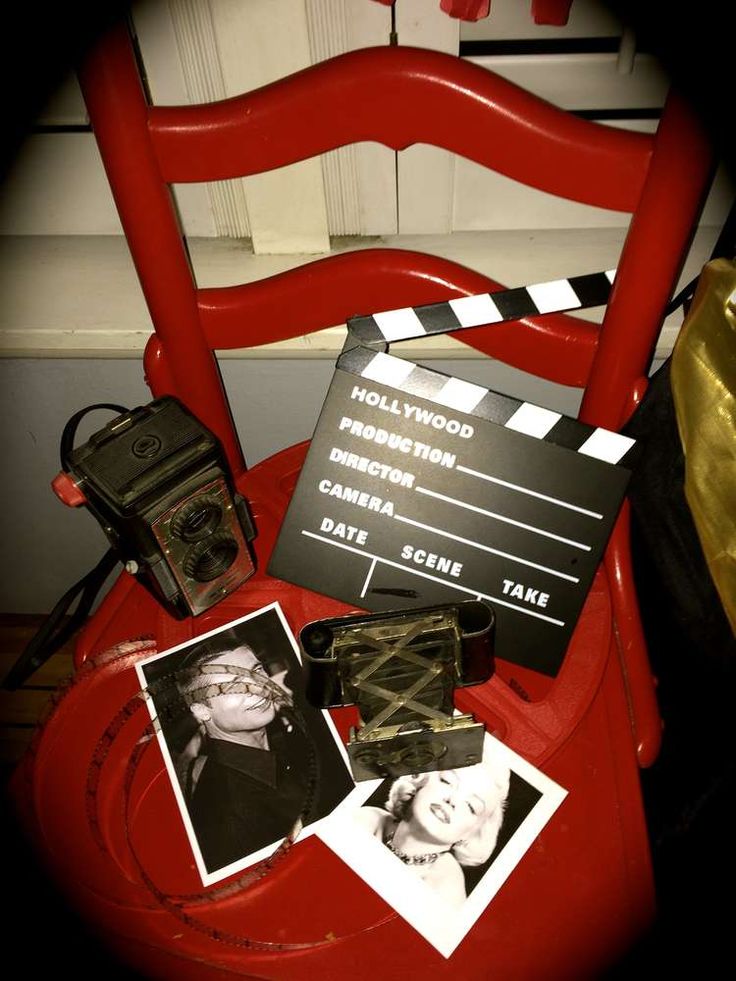 a red chair with some pictures and a movie clapper sitting on top of it