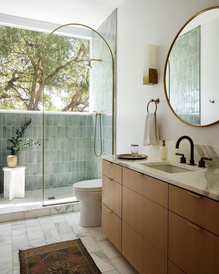 a bathroom with two sinks, a toilet and a walk in shower next to a large window