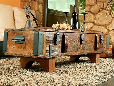 an old trunk sitting on top of a rug in front of a stone wall and window