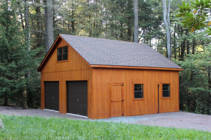 a two car garage in the middle of a wooded area