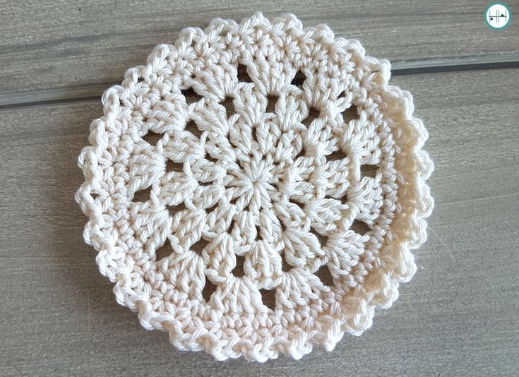 a white crocheted doily sitting on top of a wooden table