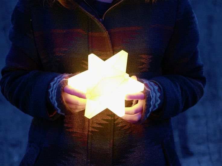 a person holding a glowing star in their hands