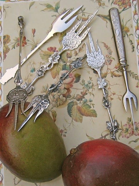 two pears, forks and spoons on a table cloth