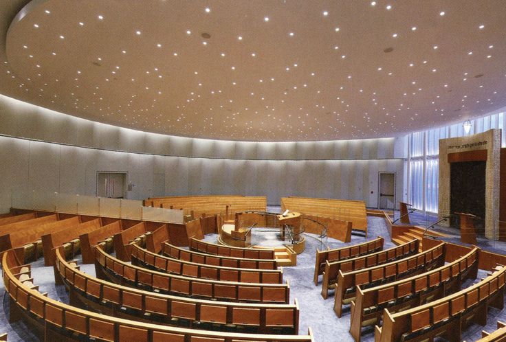 an empty auditorium with rows of seats in the center and ceiling lights on either side