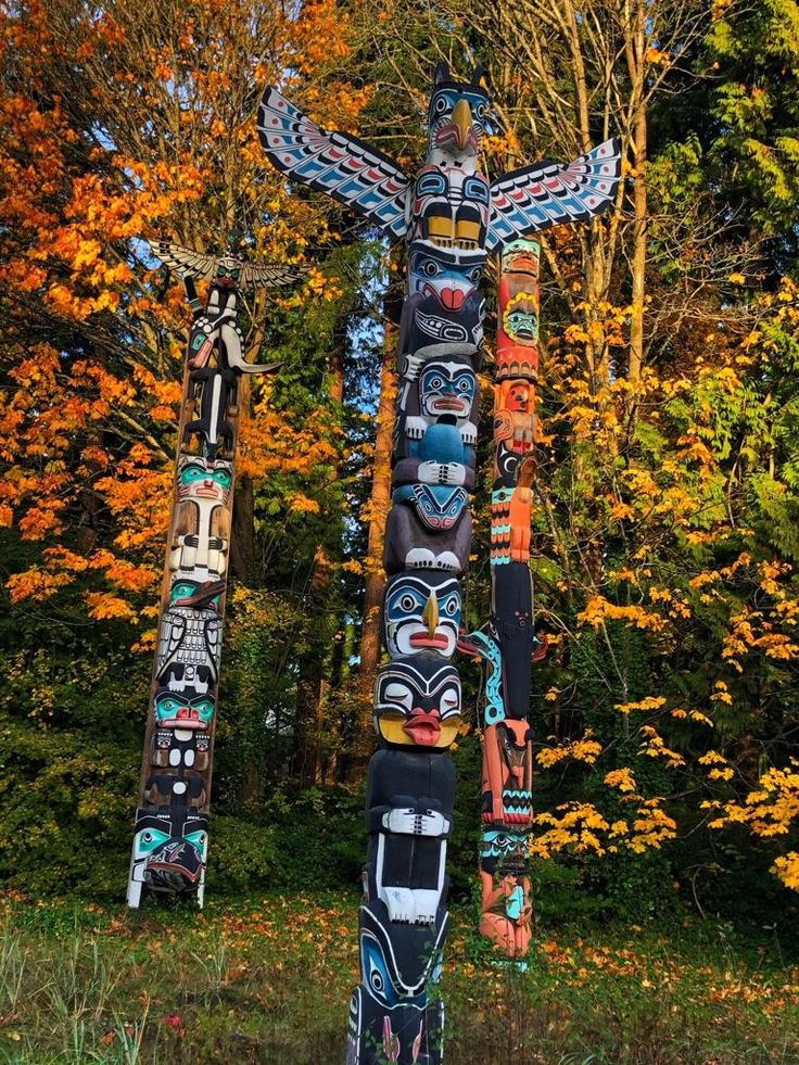 two totems are standing in front of some trees