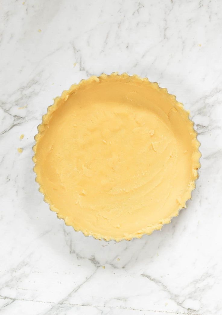 an uncooked pie crust on a marble counter top