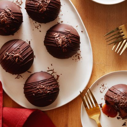 chocolate covered desserts on plates with forks and utensils next to them, ready to be eaten