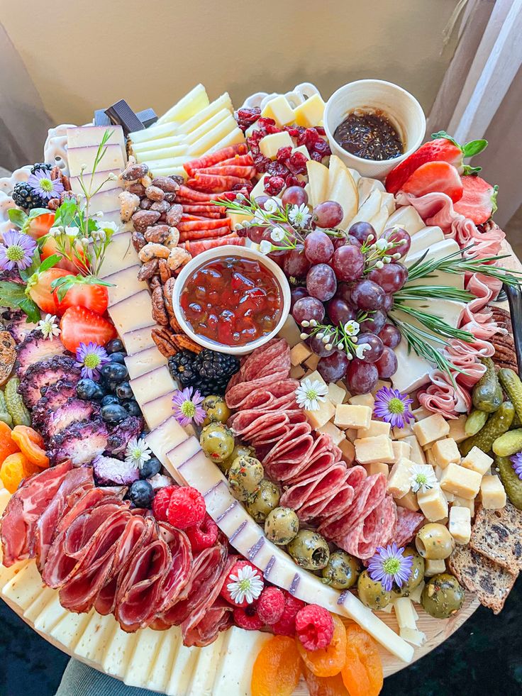 a platter filled with different types of cheese and meats