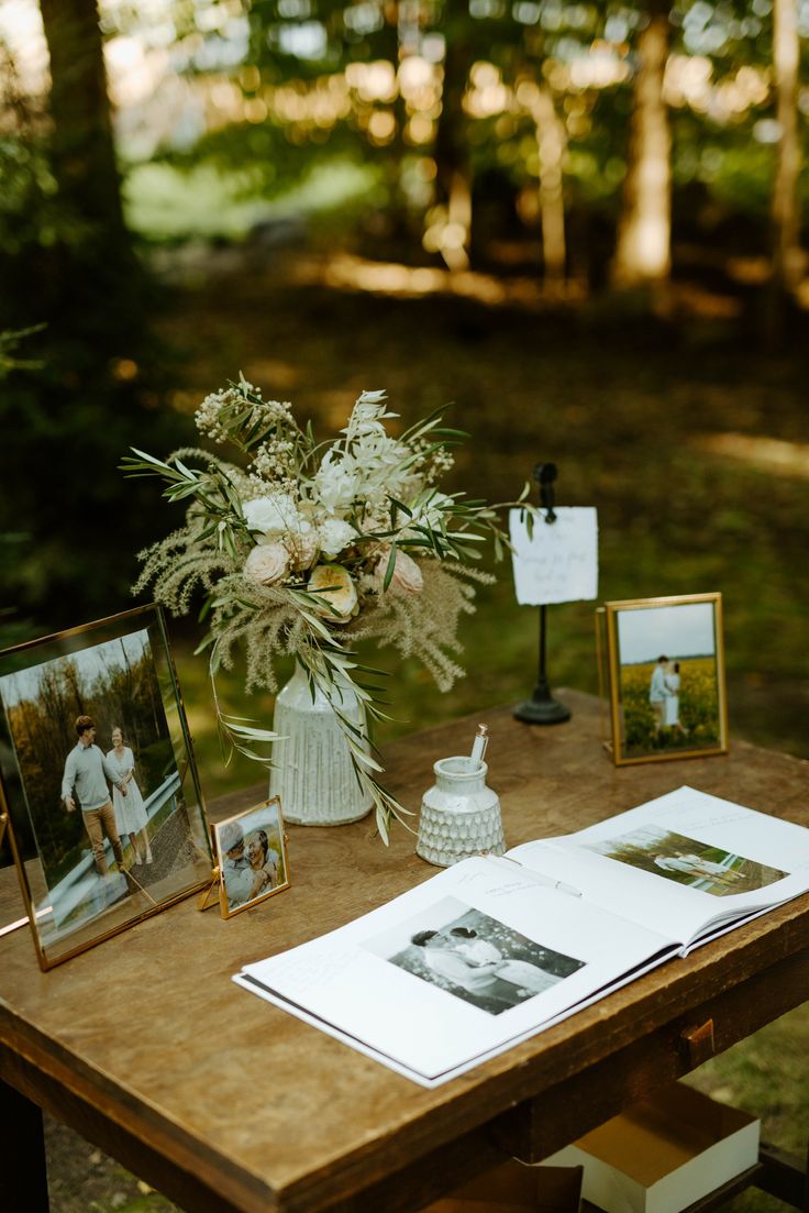 a wooden table topped with pictures and flowers