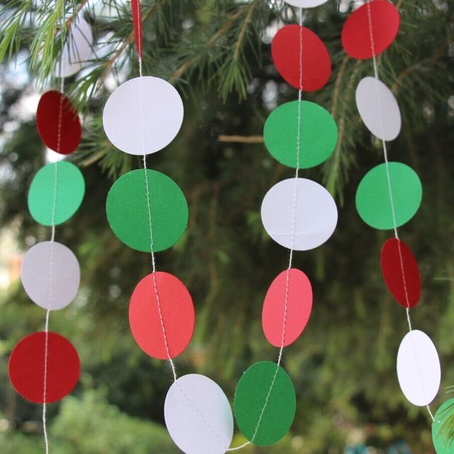 some paper balls hanging from a christmas tree with red, green and white circles on them