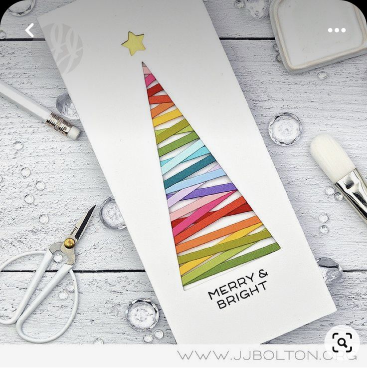 a card with a christmas tree made out of colored paper and scissors on the table