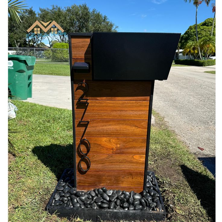 a wooden phone booth sitting in the grass