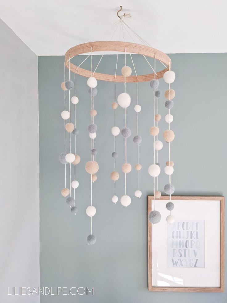 a white and gray mobile hanging from the ceiling next to a framed photograph on a wall