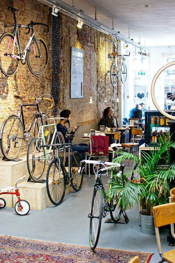 people sitting at tables with bicycles hanging from the ceiling