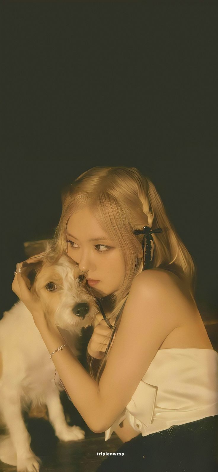 a young woman holding a dog in her lap and looking at it's face