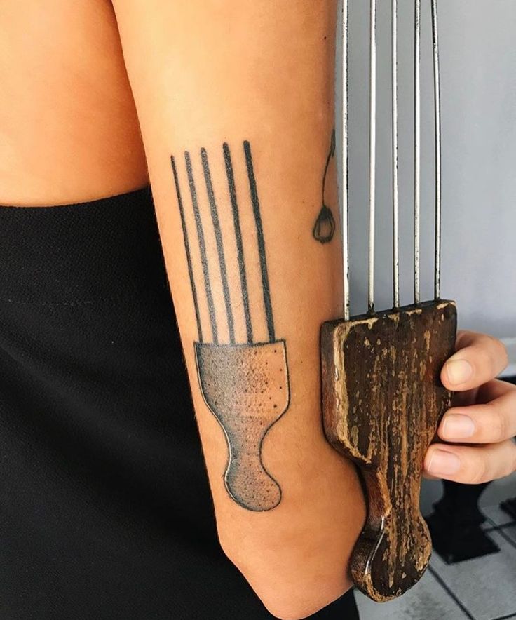 a woman with a tattoo on her arm holding an instrument